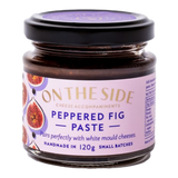 The Artisan Cheese Room Peppered Fig Paste in a small glass jar with a purple label featuring fig illustrations.
