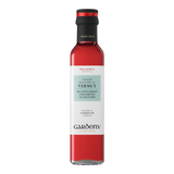 The Artisan Cheese Room Gardeny Vermut Vinegar in a clear glass bottle with a red liquid and black cap.