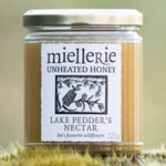 The Artisan Cheese Room Miellerie Lake Peddar's Nectar unheated honey in a glass jar resting on mossy ground