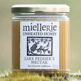 The Artisan Cheese Room Miellerie Lake Peddar's Nectar unheated honey in a glass jar resting on mossy ground