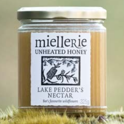 The Artisan Cheese Room Miellerie Lake Peddar's Nectar unheated honey in a glass jar resting on mossy ground