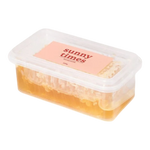 The Artisan Cheese Room Sunny Times raw honeycomb in a clear plastic container with a pink label on a white background